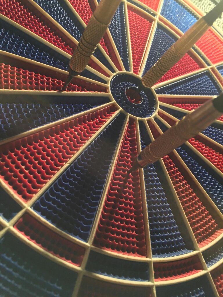 A detailed view of a dartboard with darts in the bullseye, showcasing a competitive sports moment.